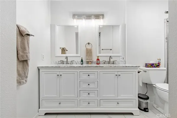 a bathroom with a granite countertop sink mirror and toilet