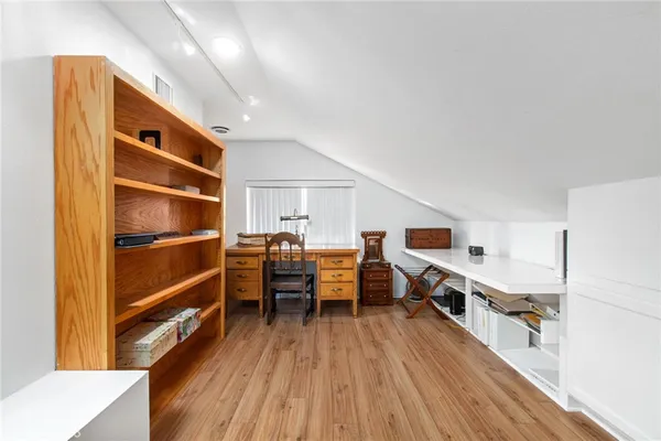 a view of a workspace with furniture and wooden floor