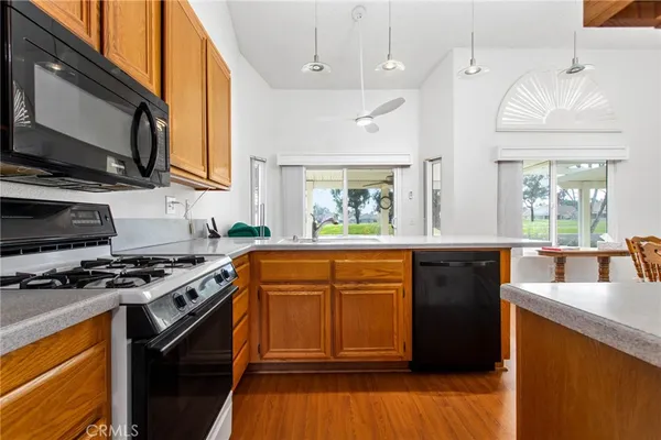 a kitchen with stainless steel appliances granite countertop a stove a sink and a microwave