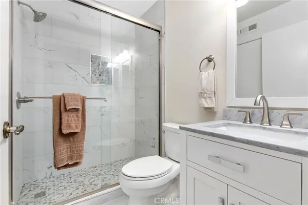 a bathroom with a granite countertop sink toilet and shower