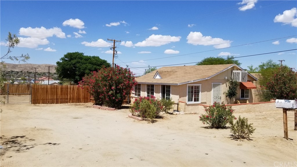 61750 Desert Air Road Joshua Tree, CA 92252 - Photo 3 of 28 a front view of a house with a yard