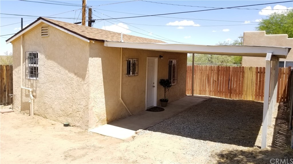 61750 Desert Air Road Joshua Tree, CA 92252 - Photo 23 of 28 a view of a white house with wooden fence