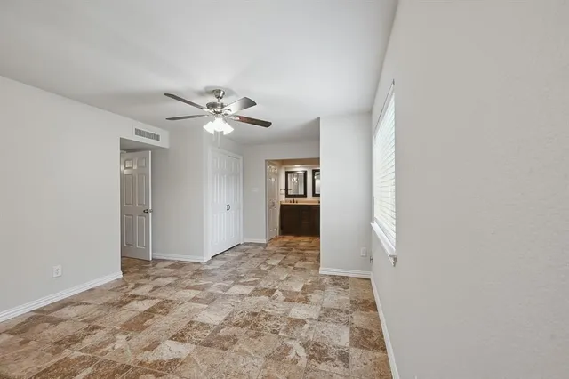 a view of a hallway with a chandelier fan and windows