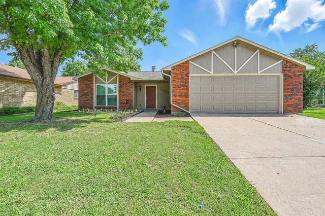 a front view of a house with a yard and trees