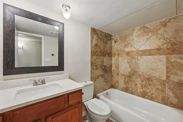 a bathroom with a granite countertop sink toilet mirror and shower