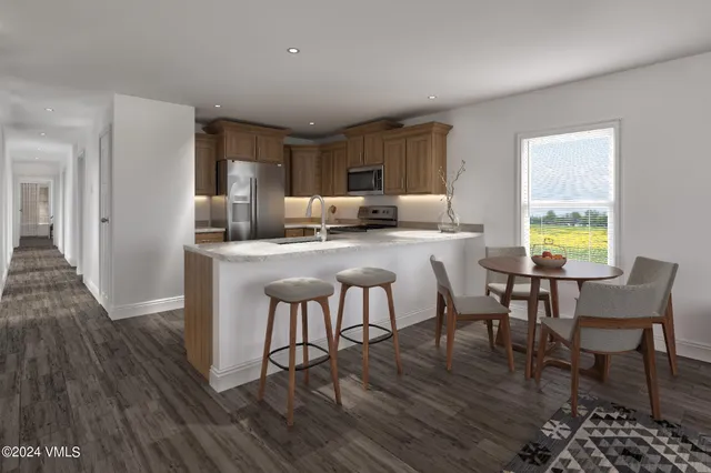 a kitchen with kitchen island granite countertop wooden floors and wooden cabinets