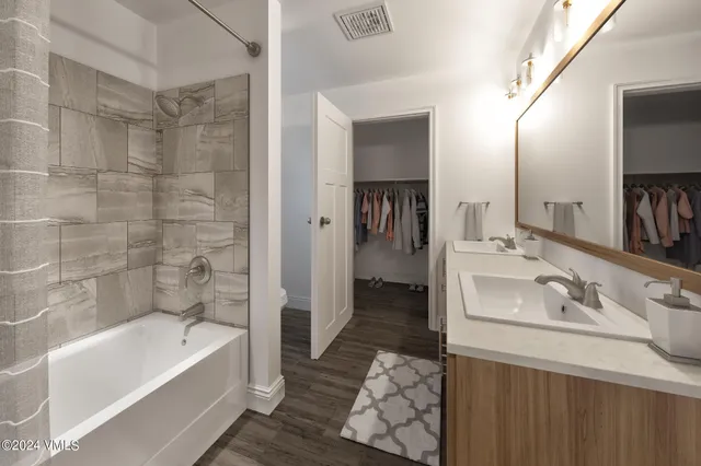 a bathroom with a tub sink and mirror
