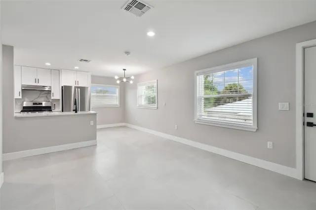 a view of a kitchen with kitchen island and stainless steel appliances
