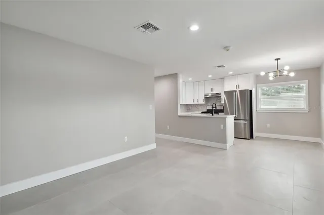 a view of kitchen with refrigerator sink and cabinets