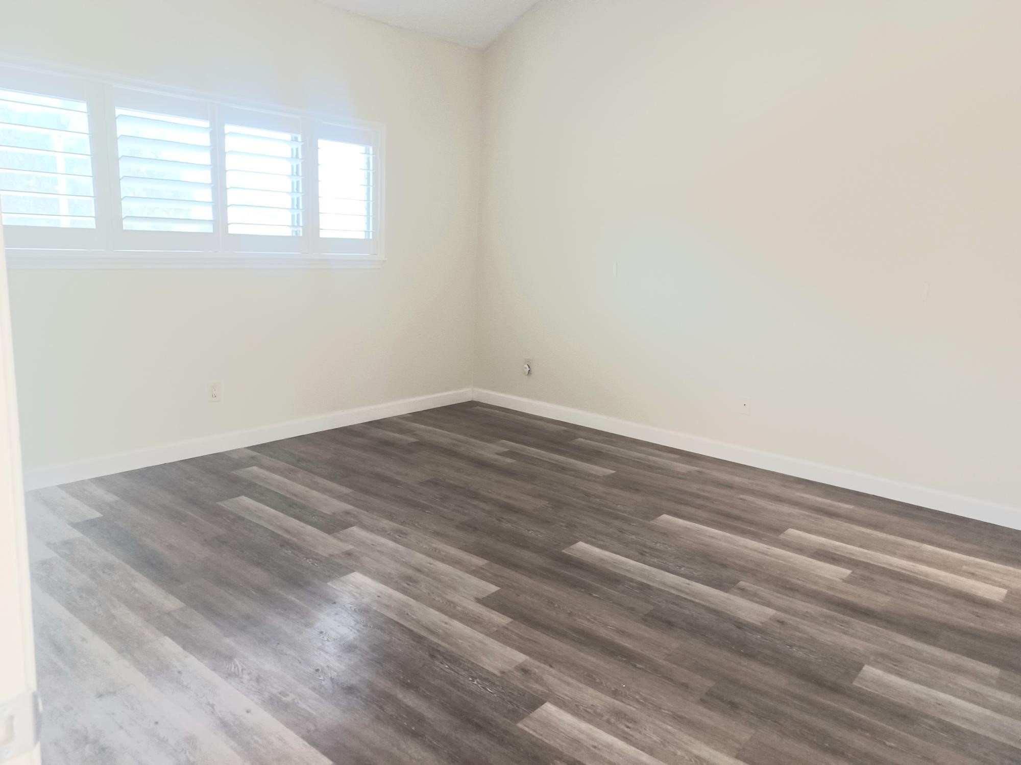 128 April Point Drive South Conroe, TX 77356 - Photo 14 of 26 an empty room with wooden floor and windows