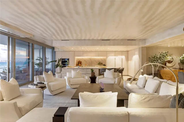 a dining room with furniture a chandelier and kitchen view