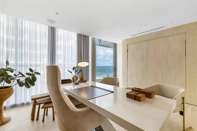 a dining room with furniture and large windows