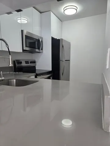 a kitchen with stainless steel appliances a refrigerator a stove a microwave and cabinets