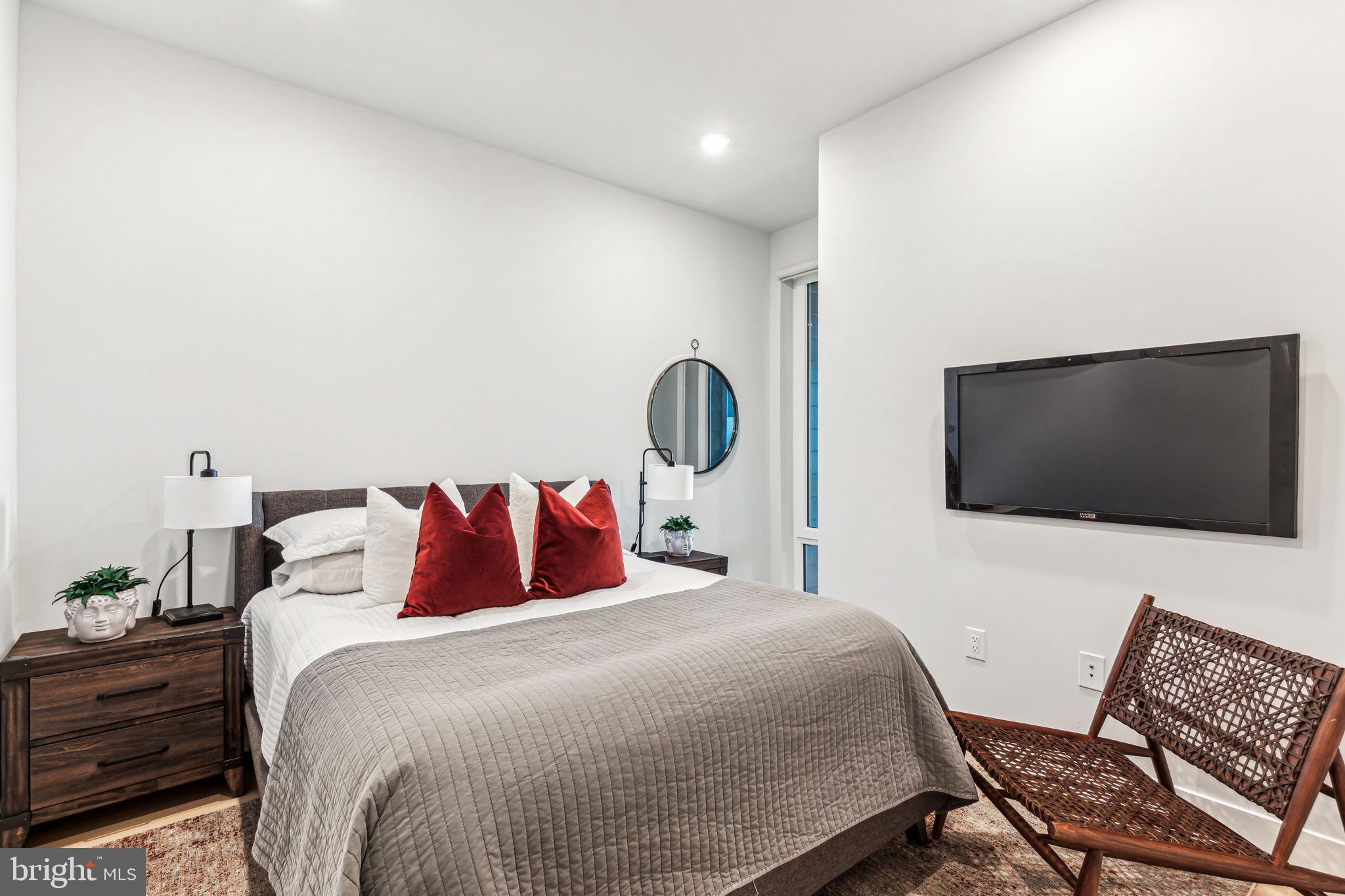 6910 Ridge Avenue, Unit 408 Philadelphia, PA 19128 - Photo 7 of 18 a bedroom with a bed and a flat screen tv