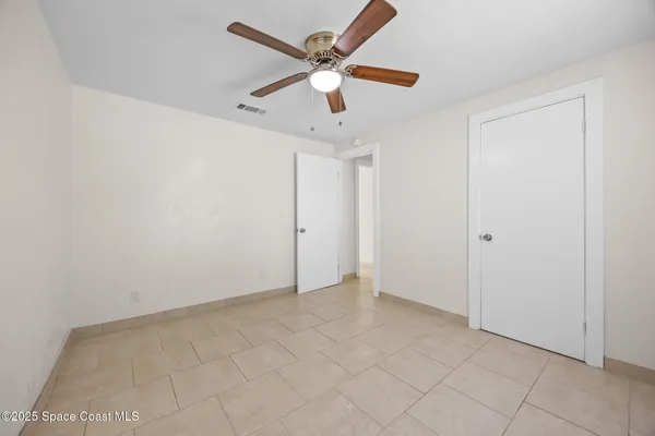 a bedroom with a bed a window and a flat screen television