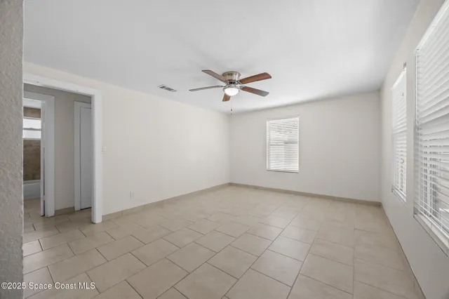 an empty room with closet and windows