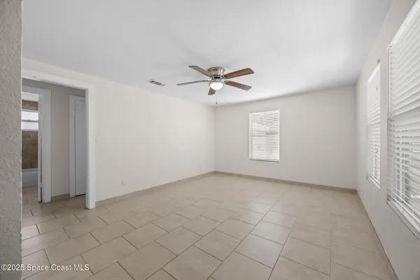 an empty room with closet and windows