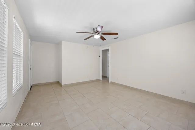 an empty room with closet and a ceiling fan