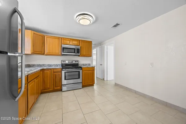 a kitchen with granite countertop a stove a sink and a microwave