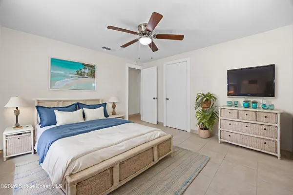 a spacious bedroom with a bed and a flat screen tv
