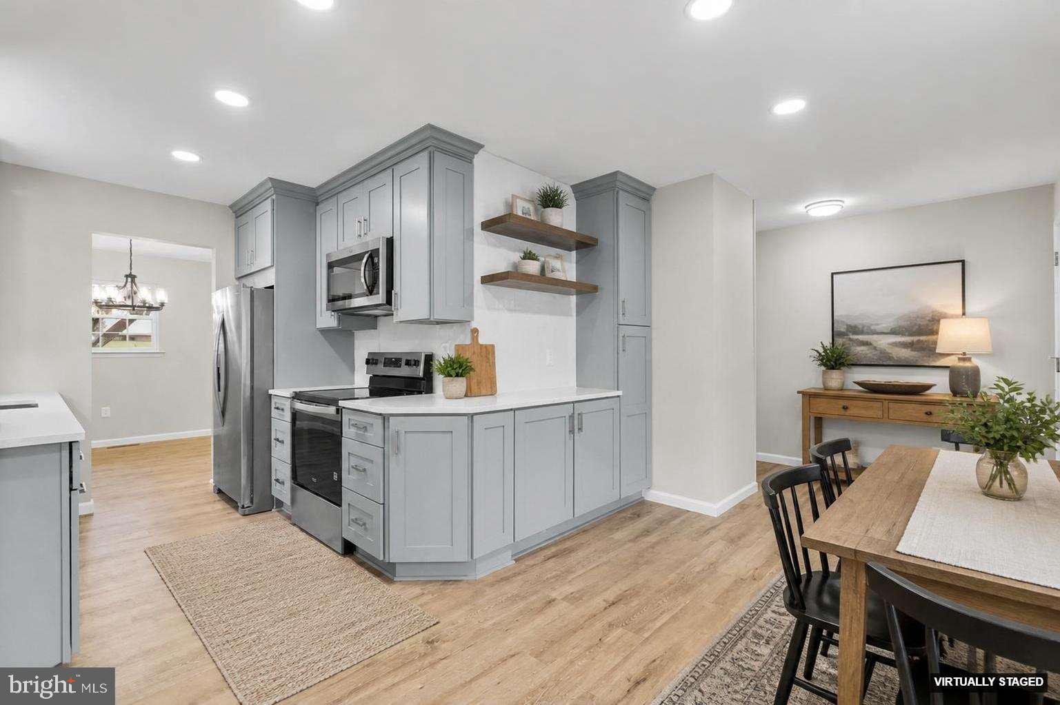 24320 Log House Road Gaithersburg, MD 20882 - Photo 11 of 43 a kitchen with stainless steel appliances a refrigerator a stove a sink a dining table and chairs