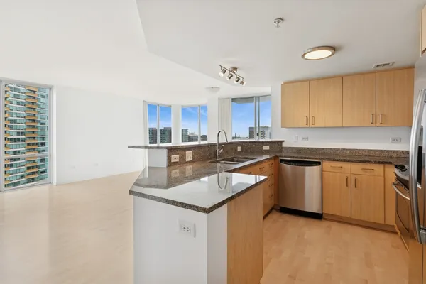 a kitchen with granite countertop a sink and cabinets