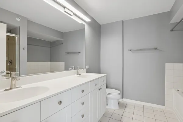 a bathroom with a granite countertop sink a toilet and a mirror