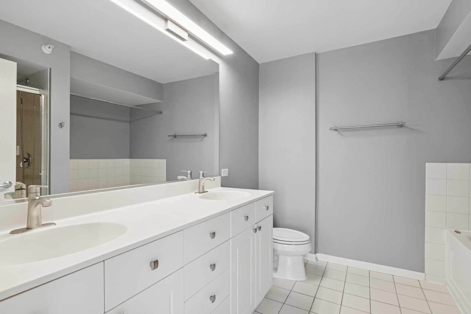1640 Maple Avenue, Unit 1202 Evanston, IL 60201 - Photo 9 of 19 a bathroom with a granite countertop sink a toilet and a mirror