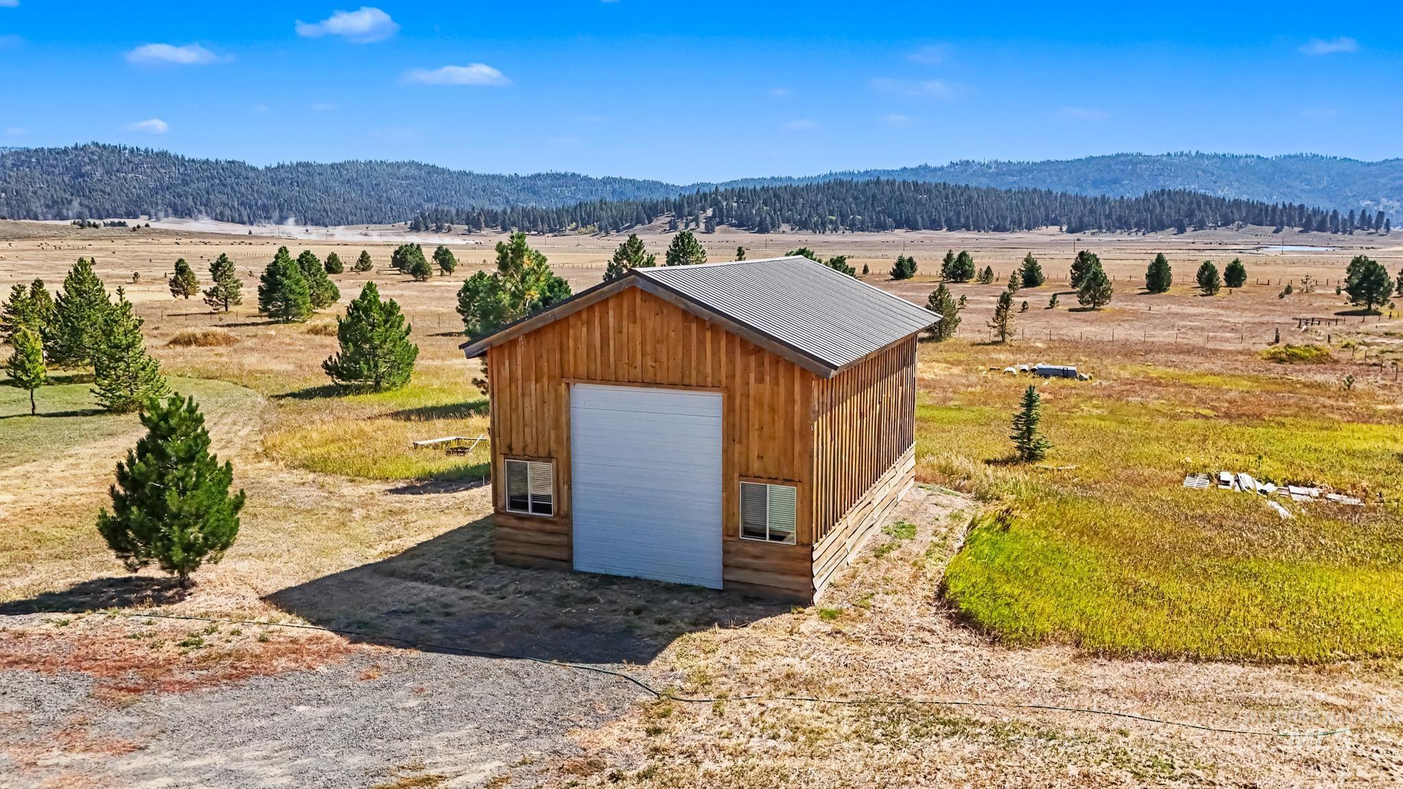 106 Wilderness Lake Road Cascade, ID 83611 - Photo 29 of 35 Wood-sided barn structure featuring a metal roof, two windows, and a large roll-up door