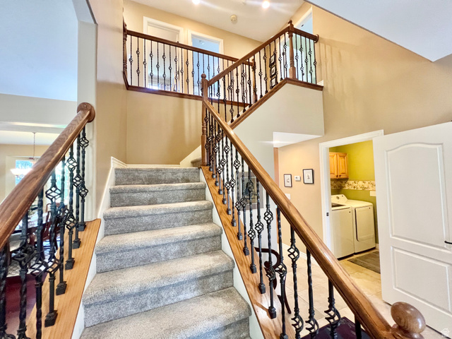 369 Culross Circle Tooele, UT 84074 - Photo 20 of 54 Grand staircase featuring carpeted treads, wood-finish handrails, and decorative wrought iron balusters