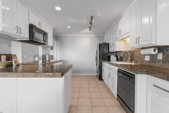 a kitchen with stainless steel appliances granite countertop a sink stove and cabinets