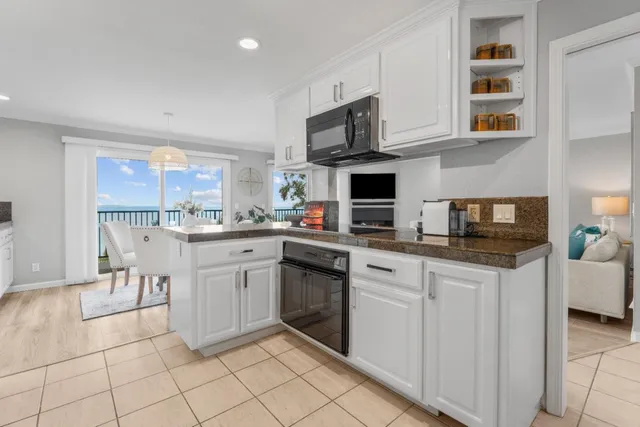 a kitchen with white cabinets a sink and white appliances