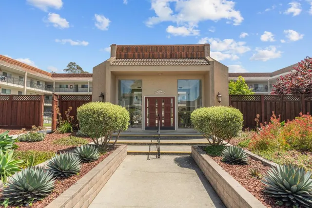 a view of a house with sitting area and large tree