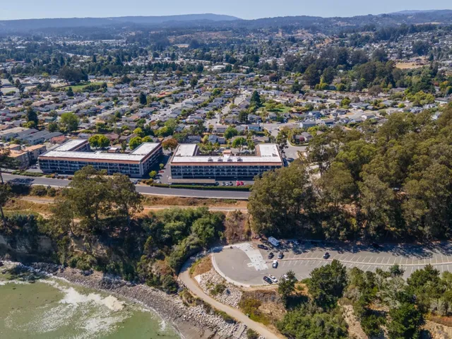 an aerial view of a house with a yard and lake view