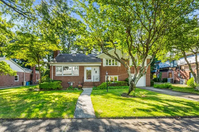 a front view of a house with yard and green space