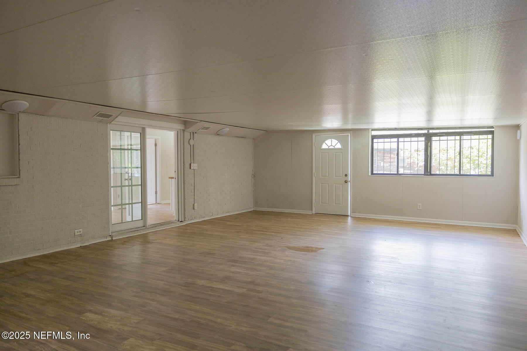 9626 Spottswood Road West Jacksonville, FL 32208 - Photo 14 of 16 an empty room with wooden floor and windows