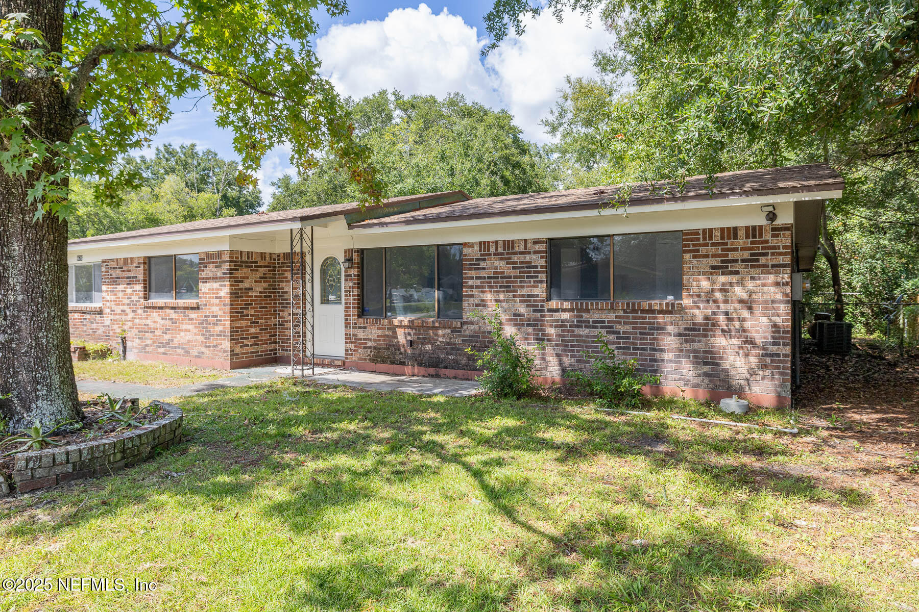 9626 Spottswood Road West Jacksonville, FL 32208 - Photo 2 of 16 a view of a backyard with plants and large tree