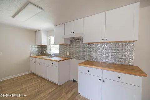 a kitchen with granite countertop white cabinets and a sink
