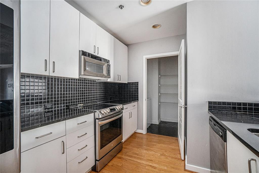 250 Pharr Road Northeast, Unit 405 Atlanta, GA 30305 - Photo 3 of 20 a kitchen with granite countertop cabinets stove and oven