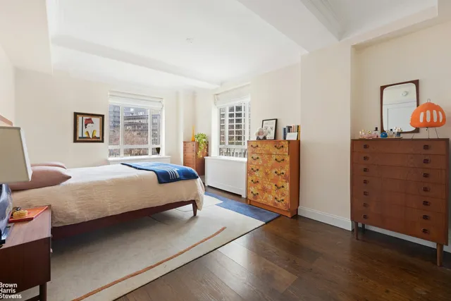 a city street with tall buildings and cars parked on road
