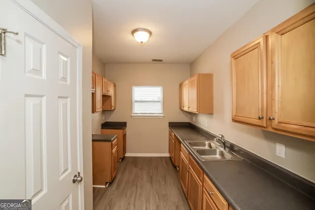 a kitchen with granite countertop a sink stove and cabinets