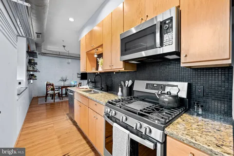 a kitchen with stainless steel appliances granite countertop a stove and a sink