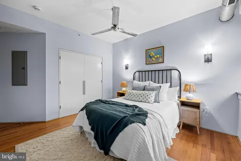 a bedroom with a bed and wooden floor