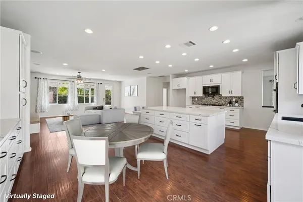 a large kitchen with dining table chairs and wooden floor