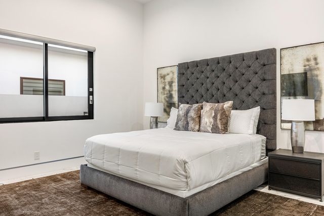 a large bed sitting in a bedroom next to a lamp