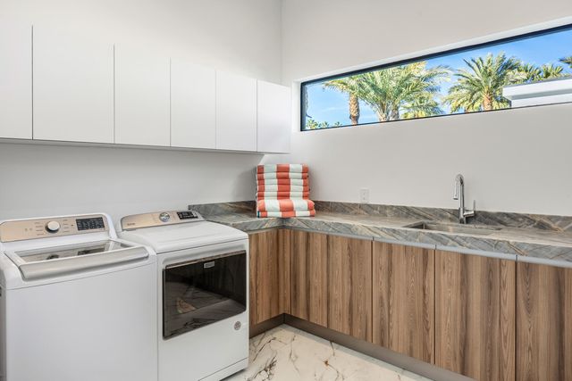 a utility room with sink dryer and washer