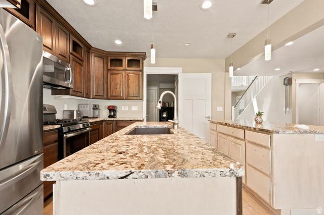 580 North 300 East Logan, UT 84321 - Photo 32 of 74 Kitchen featuring dual islands with stone countertops, stainless steel appliances, dark wood cabinetry, and recessed lighting