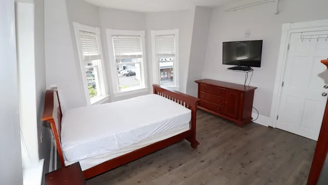 a bedroom with a bed and a flat screen tv