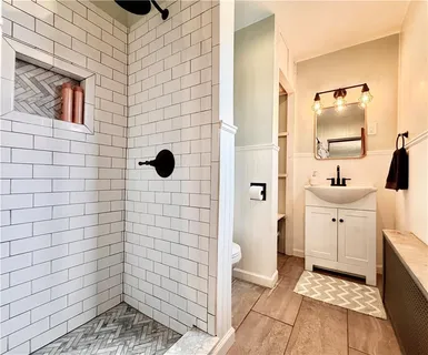 a bathroom with a sink a toilet and shower