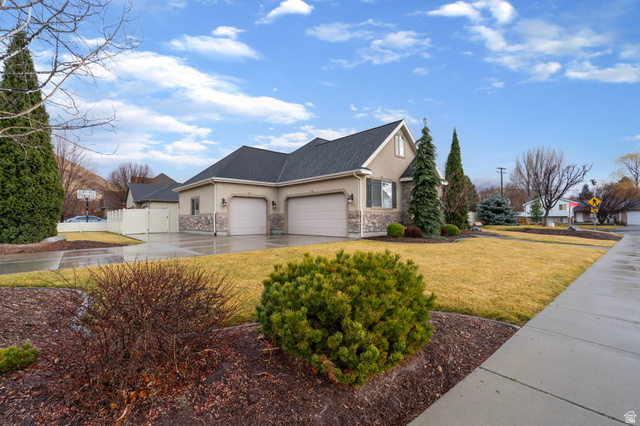 557 South 1470th Street East Springville, UT 84663 - Photo 3 of 46 View of home's exterior with stucco siding, driveway, a 3 car garage, stone siding, and a gate